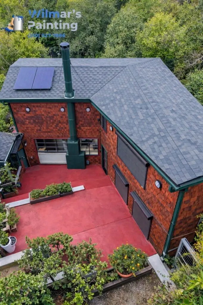 Aerial view of a dark red and grey modern home with a repainted patio deck by Wilmar's Painting