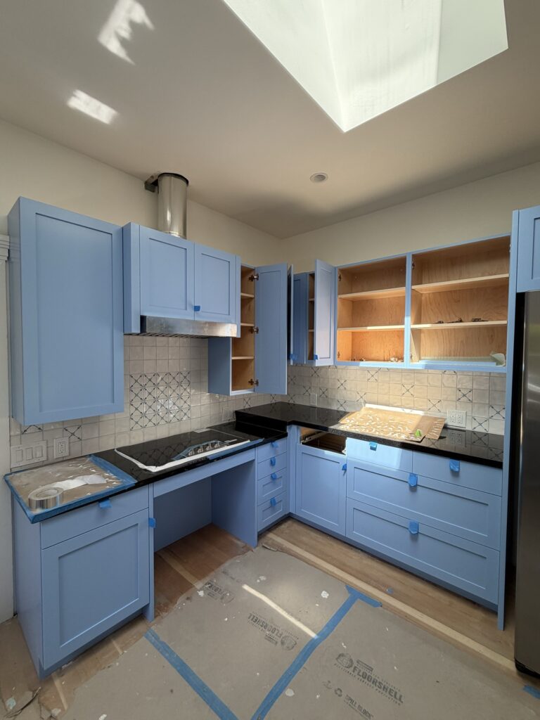 Kitchen cabinets freshly painted a soft blue, detail view, by Wilmar's Painting