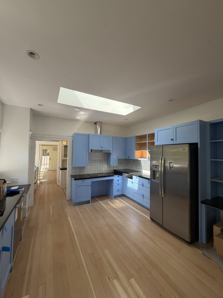 Blue painted kitchen cabinets in a bright kitchen, wide view, by Wilmar's Painting