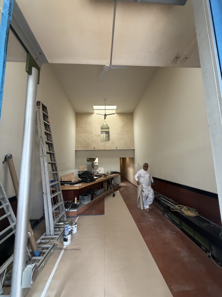 Commercial hallway painting in progress by a Wilmar's Painting crew member