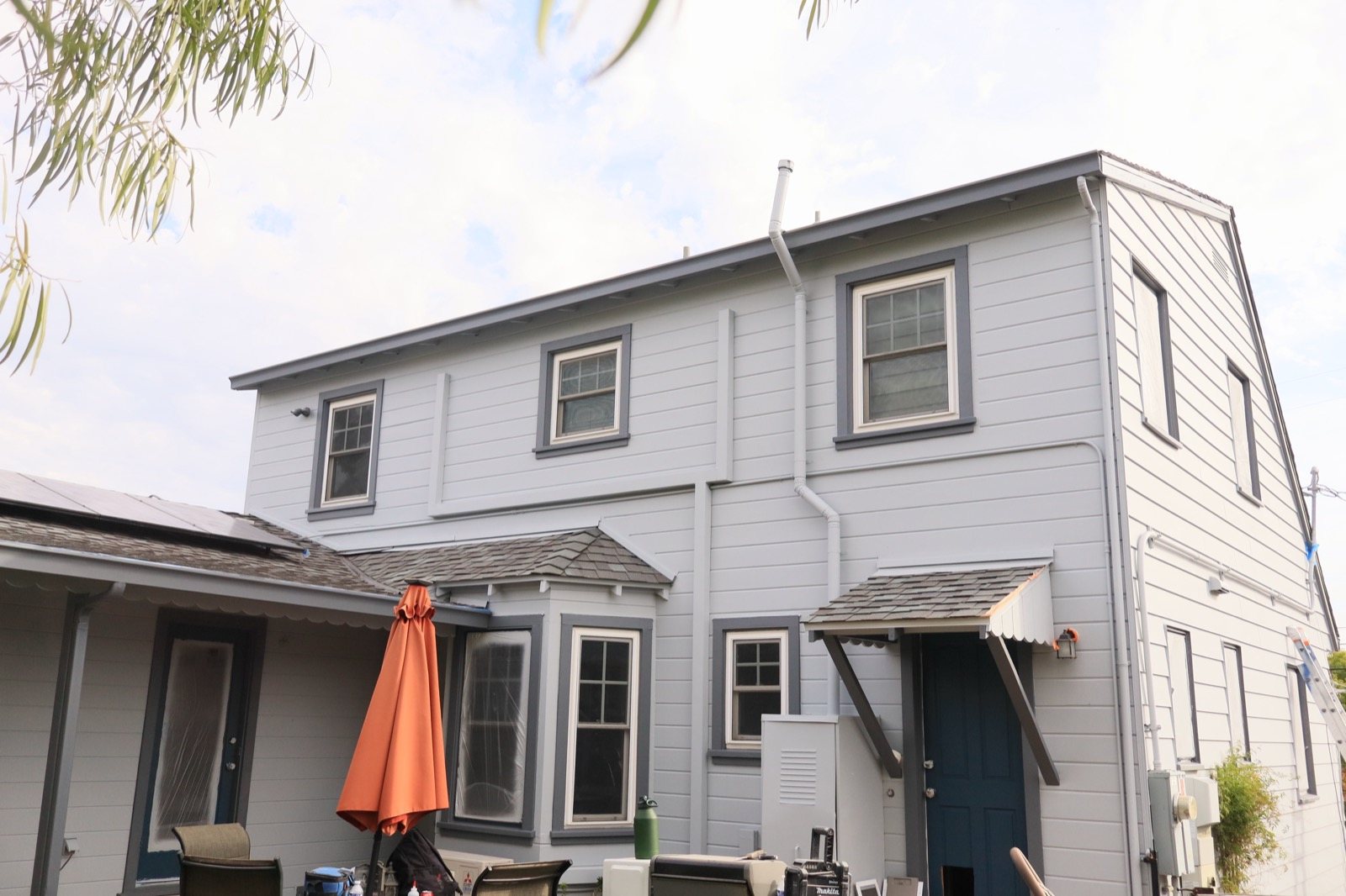 Grey home exterior repaint with patio