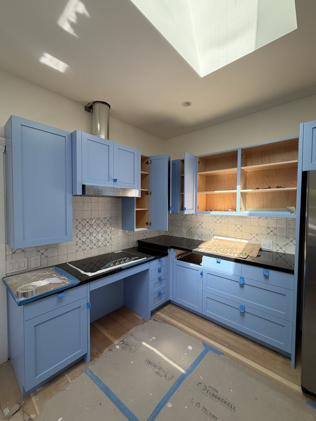Blue kitchen cabinet painting with skylight